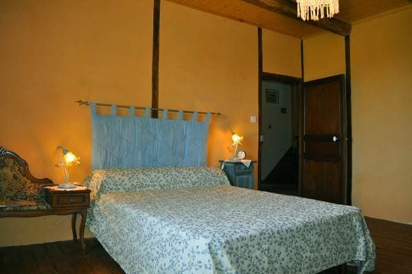Chambre Bleue du gîte Mare Sala, murs en pierre et literie soignée