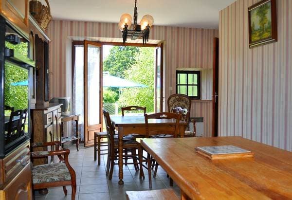 Salon commun avec cheminée en pierre, canapés et ambiance chaleureuse.